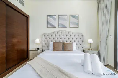 a bedroom with a large white bed with a large headboard at Charming 1BR Apartment in Sparkle Tower 1, Dubai Marina by Deluxe Holiday Homes in Dubai