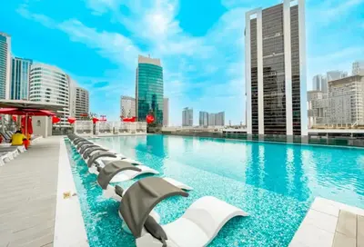 a swimming pool with chaise lounge chairs on a building at City Retreat MAG 318,Downtown Dubai 5 minutes walk to Dubai mall in Dubai