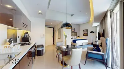 a kitchen and living room with a table and chairs at Luxury Studio in Business Bay in Dubai