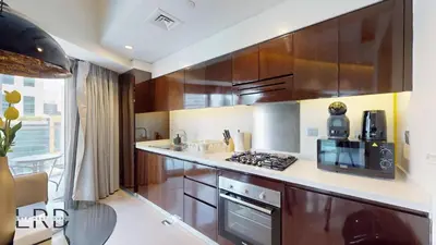 a kitchen with wooden cabinets and a stove top oven at Luxury Studio in Business Bay in Dubai