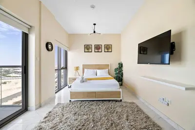 a bedroom with a bed and a flat screen tv at Chic Urban Escape at Studio MAG 422 in Dubai