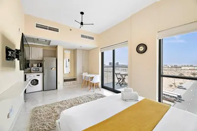 a bedroom with a large bed and a large window at Chic Urban Escape at Studio MAG 422 in Dubai