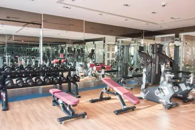 a gym with lots of exercise equipment and mirrors at Furnished Studio Ready to Move-in in Dubai
