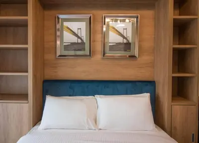 a bedroom with a bed with two mirrors above it at Furnished Studio Ready to Move-in in Dubai
