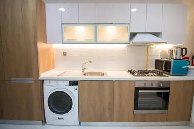 a kitchen with a washing machine and a sink at Furnished Studio Ready to Move-in in Dubai