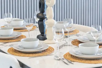 a table set with white plates and wine glasses at Luxury Stay with Burj Khalifa Views & Infinity Pool in Dubai