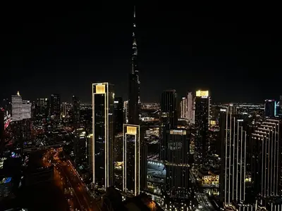 a city skyline at night with a tall building at Luxury Stay with Burj Khalifa Views & Infinity Pool in Dubai