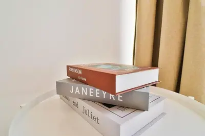 three books sitting on top of a table at Bohemian Bliss 1 BR Apartment in Dubai
