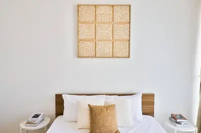 a bedroom with a bed and a picture on the wall at Bohemian Bliss 1 BR Apartment in Dubai