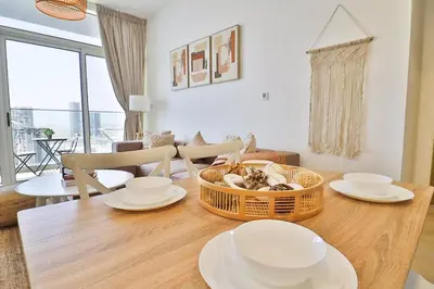 a dining room table with plates and a basket of food at Bohemian Bliss 1 BR Apartment in Dubai