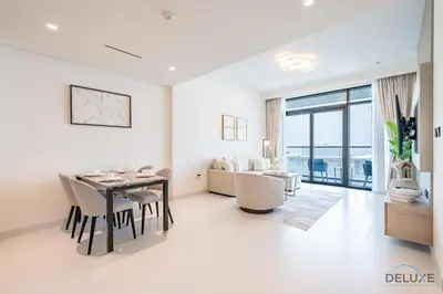 a dining room with a table and chairs and a living room at Charming 1BR Apartment at Marina Vista Tower 2 Emaar Beachfront Dubai Marina by Deluxe Holiday Homes in Dubai