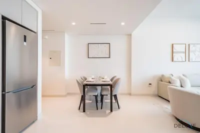a dining room with a table and a couch at Charming 1BR Apartment at Marina Vista Tower 2 Emaar Beachfront Dubai Marina by Deluxe Holiday Homes in Dubai