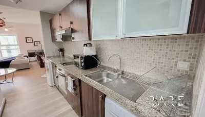 a kitchen with a sink and a counter top at Rare Holiday Homes - Near Madame Tussauds - Goldcrest Executive - R3012 - Jumeirah Lake Towers in Dubai