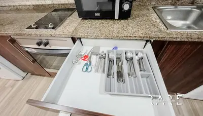 a kitchen counter with knives and utensils in a drawer at Rare Holiday Homes - Near Madame Tussauds - Goldcrest Executive - R3012 - Jumeirah Lake Towers in Dubai