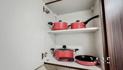 two red pots and pans on a shelf in a kitchen at Rare Holiday Homes - Near Madame Tussauds - Goldcrest Executive - R3012 - Jumeirah Lake Towers in Dubai