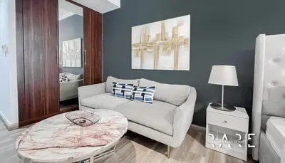 a living room with a couch and a table at Rare Holiday Homes - Near Madame Tussauds - Goldcrest Executive - R3012 - Jumeirah Lake Towers in Dubai