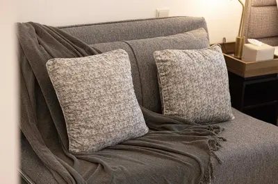 a couch with two pillows on top of it at SmartStay at Carson Tower - Panoramic City Views - Modern Luxury Apartments in Dubai