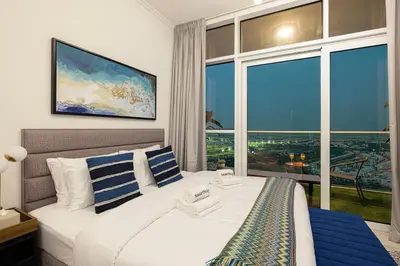 a bedroom with a bed with a large window at SmartStay at Carson Tower - Panoramic City Views - Modern Luxury Apartments in Dubai