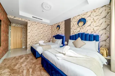 two beds in a room with blue and white at Amazing 2BR Apartment in Paramount Hotel Midtown, 64th-Floor Infinity Pool & Burj Khalifa Views in Dubai