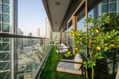 a balcony with chairs and plants on a building at Amazing 2BR Apartment in Paramount Hotel Midtown, 64th-Floor Infinity Pool & Burj Khalifa Views in Dubai