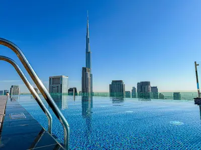 a swimming pool with a view of the burj skyscraper at Amazing 2BR Apartment in Paramount Hotel Midtown, 64th-Floor Infinity Pool & Burj Khalifa Views in Dubai