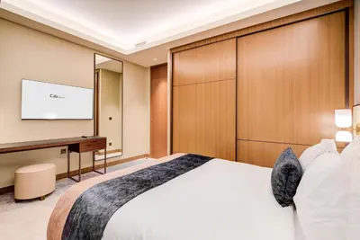 a hotel room with a bed and a flat screen tv at CitiHome-2BR at Address Opera in the Heart of Downtown in Dubai