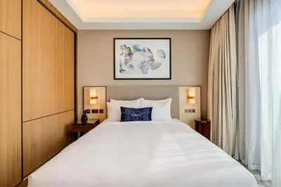 a bedroom with a large white bed and a window at CitiHome-2BR at Address Opera in the Heart of Downtown in Dubai