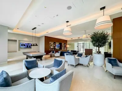 a lobby with chairs and tables and a pool table at CitiHome-2BR at Address Opera in the Heart of Downtown in Dubai