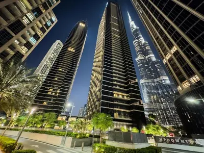 a group of tall buildings in a city at night at CitiHome-2BR at Address Opera in the Heart of Downtown in Dubai