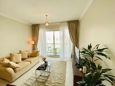 a living room with a couch and a table at Greens in Dubai