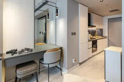 a kitchen with a desk and chairs in a room at Elegant MAG 318 Studio Near Dubai Mall in Dubai