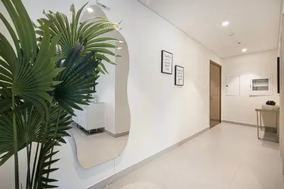 a hallway with white walls and a plant at Lux 3BR With Spectacular Downtown Views in Dubai