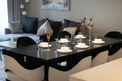 a black dining table with chairs and a couch at Lux 3BR With Spectacular Downtown Views in Dubai