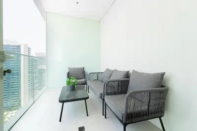 a living room with two chairs and a table at Luxury Sunrise Bay 1BR - Panoramic Sea View with Exclusive Amenities, by Think Realty in Dubai