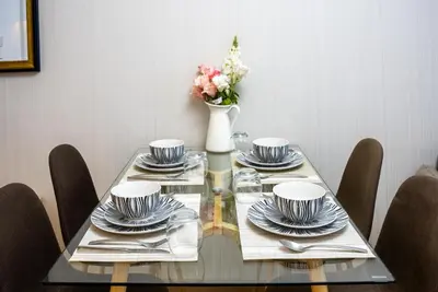a dining table with plates and a vase of flowers at Dubai marina - Luxury Studio Apartment in Dubai