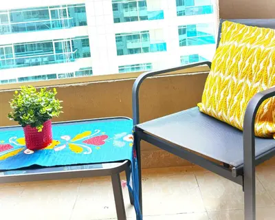 a blue chair with a plant on a balcony at Great Location in Dubai Marina!! in Dubai