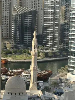 a tall white building in front of a city at Great Location in Dubai Marina!! in Dubai