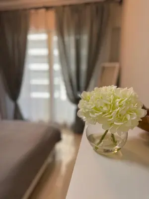 a flower in a glass vase on a table at Great Location in Dubai Marina!! in Dubai