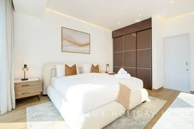 a white bedroom with a large white bed and a cabinet at LUX The JW Marina Suite 2 in Dubai