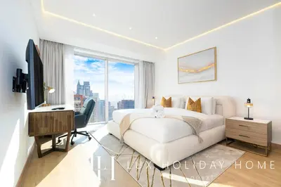 a white bedroom with a large bed and a desk at LUX The JW Marina Suite 2 in Dubai
