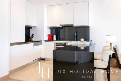 a kitchen with white cabinets and a black sink at LUX The JW Marina Suite 2 in Dubai