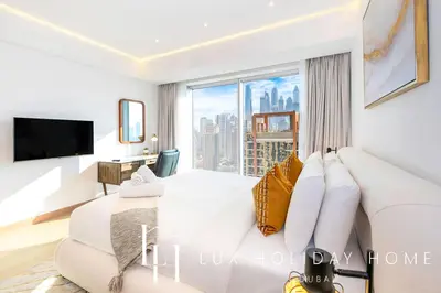 a bedroom with a large white bed and a large window at LUX The JW Marina Suite 2 in Dubai