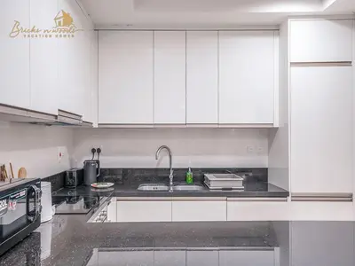 a kitchen with white cabinets and a sink at Modern High Floor Canal View1 BHK in Dubai