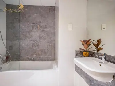 a bathroom with a sink and a shower and a tub at Modern High Floor Canal View1 BHK in Dubai