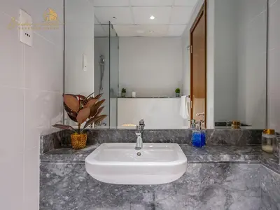 a bathroom with a white sink and a mirror at Modern High Floor Canal View1 BHK in Dubai