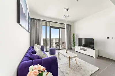 a living room with a purple couch and a tv at Elegant 1 Bedroom in Creek Edge in Dubai
