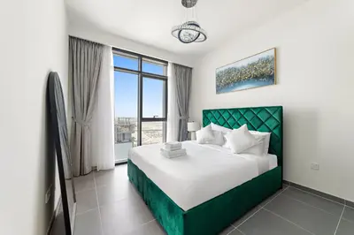 a bedroom with a large bed and a large window at Elegant 1 Bedroom in Creek Edge in Dubai
