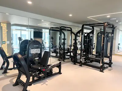 a gym with a lot of treadmills and ellipticals at Elegant 1 Bedroom in Creek Edge in Dubai