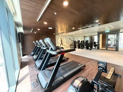 a gym with a row of treadmills and exercise bikes at Elegant 1 Bedroom in Creek Edge in Dubai