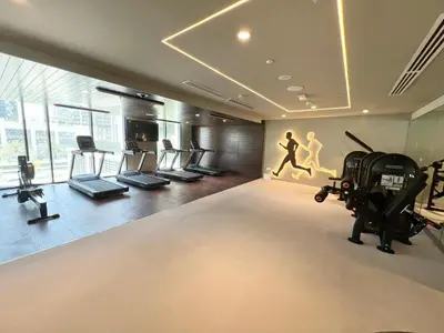 a gym with treadmills and treadles in a room at Elegant 1 Bedroom in Creek Edge in Dubai